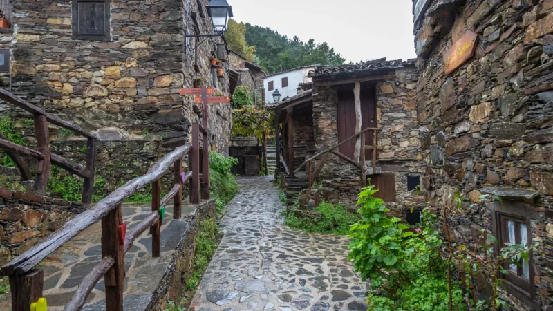 Rua estreita entre casas tradicionais de xisto na aldeia de Talasnal, na Serra da Lousã.