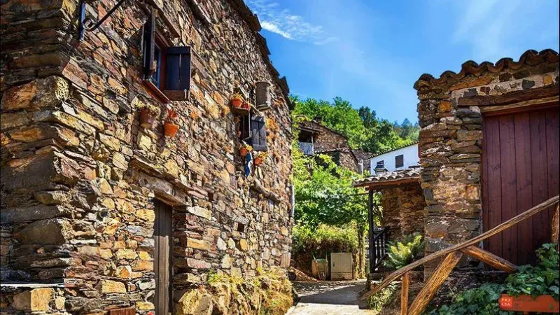 Rua estreita entre casas tradicionais de xisto na aldeia de Talasnal, na Serra da Lousã.